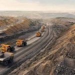 Open-pit mining site with heavy trucks transporting materials, reflecting Saudi Arabia’s industrial growth under Vision 2030.
